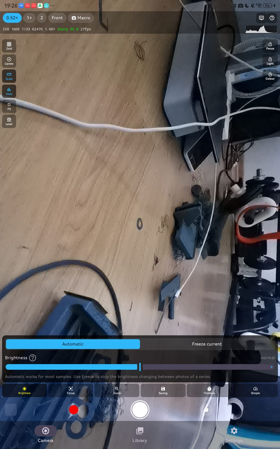 The SciCope phone app on Android: the live camera picture with lens buttons, an ISO, exposure and sharpness readout, grid, scale and level overlays, and the brightness control set to Automatic.